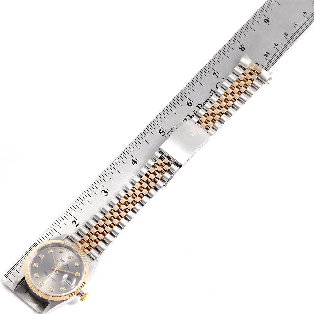The image shows a Rolex Datejust 16233 Men's Steel and Gold (two tone) Silver Dial 16233 Men's Steel and Gold (two tone) Silver Dial watch laid flat next to a ruler, displaying its face, bracelet, and clasp.