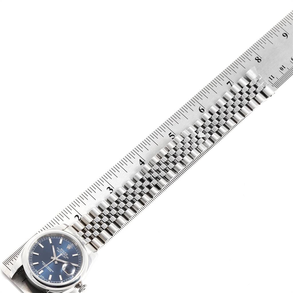 This image shows a Rolex Datejust 116200 Men
s Stainless Steel Blue Dial 116200 Men
s Stainless Steel Blue Dial watch lying flat with a ruler to measure the length of its bracelet.