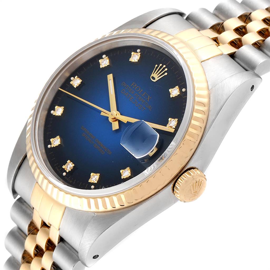 The image shows a Rolex Datejust 16233 Men
s Steel and Gold (two tone) Blue Dial 16233 Men
s Steel and Gold (two tone) Blue Dial watch at a tilted angle, highlighting the blue dial, gold fluted bezel, and bracelet.