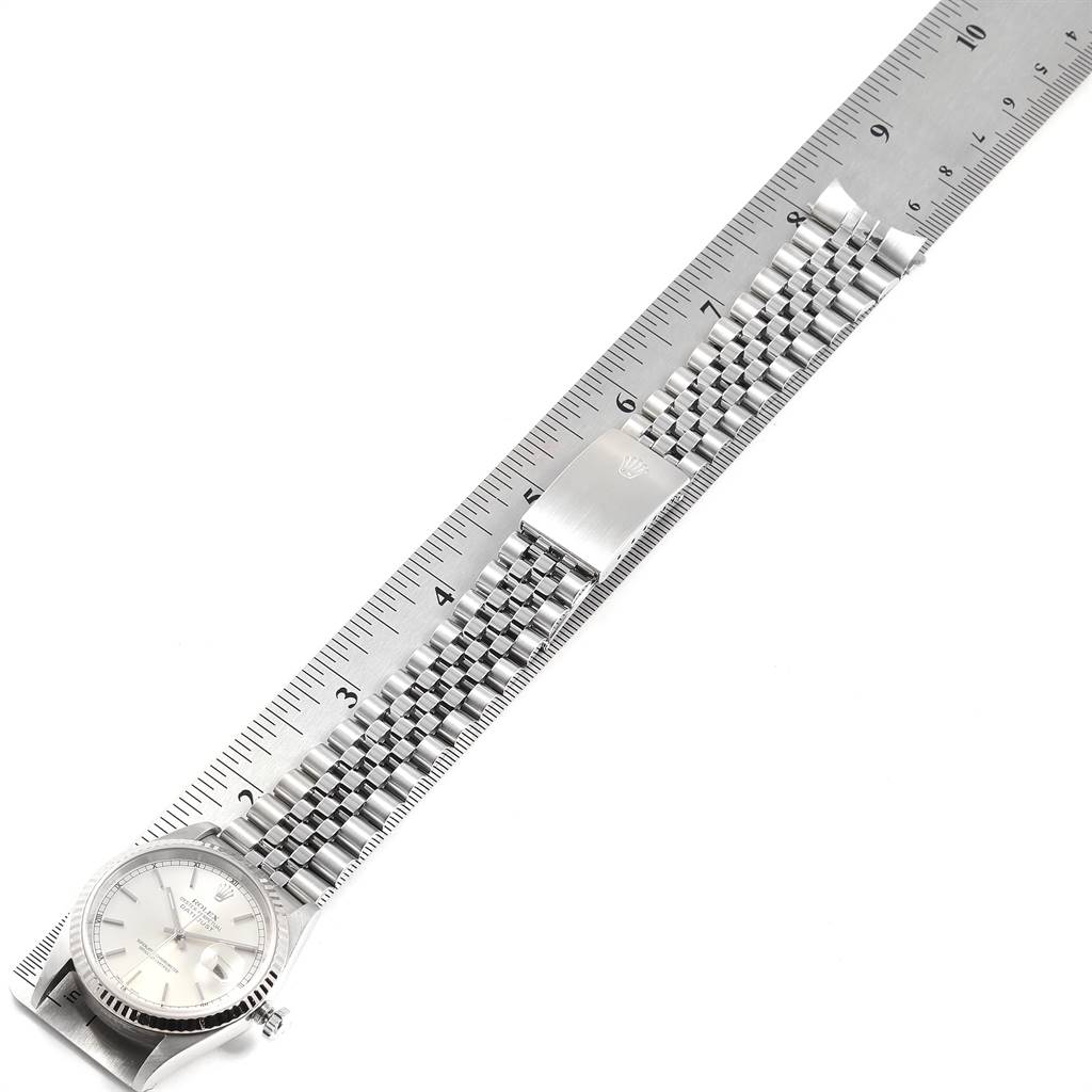 The Rolex Datejust 16234 Men's Stainless Steel Silver Dial 16234 Men's Stainless Steel Silver Dial watch is shown from an overhead angle, highlighting the face, bracelet, and clasp next to a ruler.