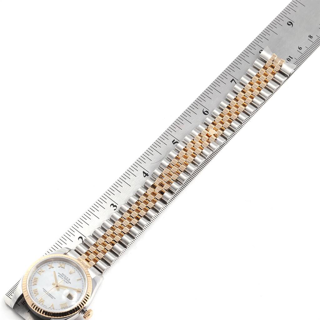 The Rolex Datejust 116233 Men's Stainless Steel Mother of Pearl Dial 116233 Men's Stainless Steel Mother of Pearl Dial watch is shown flat with its band aligned along a measuring ruler, displaying the face, bezel, and full bracelet.