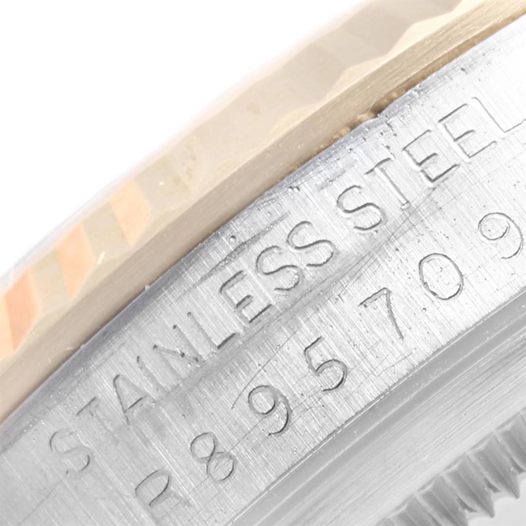This close-up image of the Rolex Datejust 16233 Men's Steel and Gold (two tone) Champagne Dial 16233 Men's Steel and Gold (two tone) Champagne Dial watch shows the engraved serial number and "STAINLESS STEEL" text on the case.