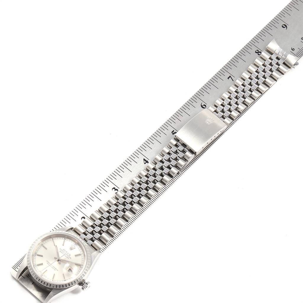 The Rolex Datejust 16220 Men's Stainless Steel Silver Dial 16220 Men's Stainless Steel Silver Dial watch is shown from a top-down angle with the bracelet extending across a ruler for measurement.