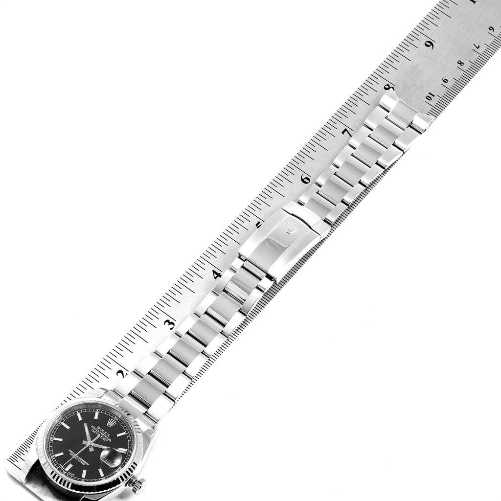 The image shows a Rolex Datejust 116234 Men's Stainless Steel Black Dial 116234 Men's Stainless Steel Black Dial watch laid flat with its bracelet extended next to a ruler for measurement.
