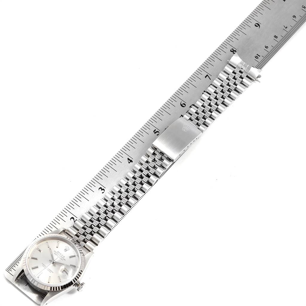The image shows a top view of a Rolex Datejust 16234 Men's Stainless Steel Silver Dial 16234 Men's Stainless Steel Silver Dial watch, including its face, Jubilee bracelet, and clasp, with a ruler for scale.
