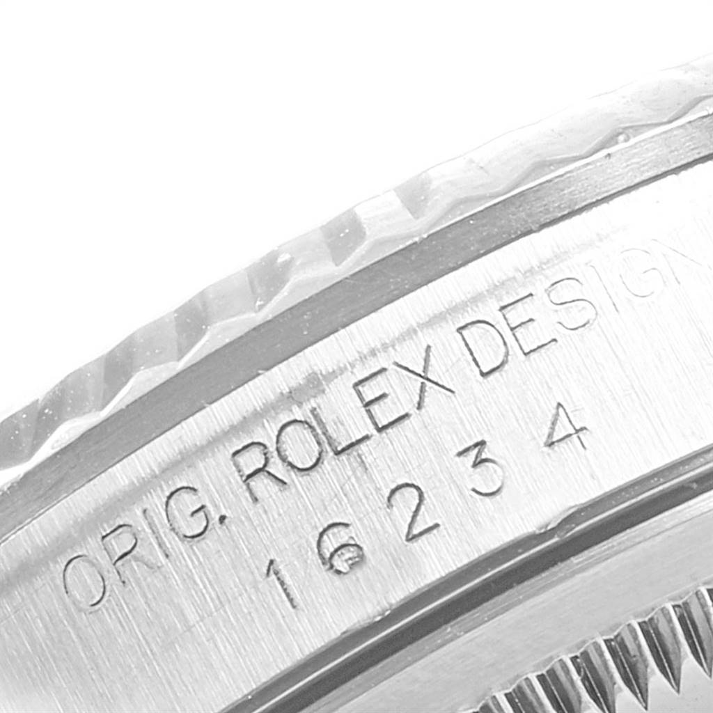 This close-up image shows the engraved text and fluted bezel of a Rolex Datejust 16234 Men's Stainless Steel White Dial 16234 Men's Stainless Steel White Dial watch.