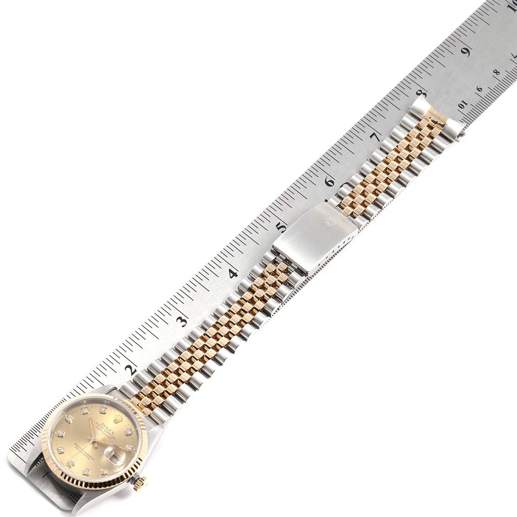The image shows a Rolex Datejust 16233 Men
s Steel and Gold (two tone) Champagne Dial 16233 Men
s Steel and Gold (two tone) Champagne Dial watch placed alongside a metal ruler with a close-up of its jubilee bracelet and clasp.