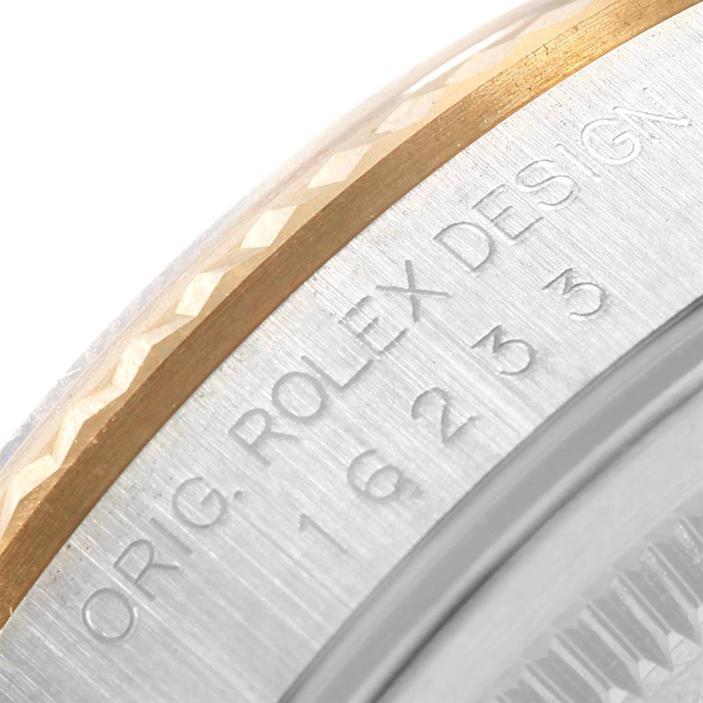 The image shows a close-up of the engraved bezel and case of a Rolex Datejust 16233 Men's Steel and Gold (two tone) Blue Dial 16233 Men's Steel and Gold (two tone) Blue Dial watch.