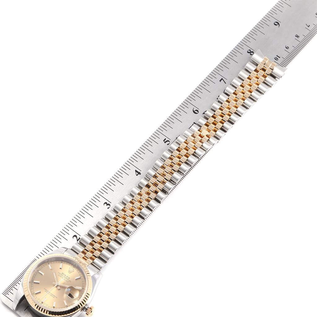 The image shows a Rolex Datejust 116233 Men's Stainless Steel Champagne Dial 116233 Men's Stainless Steel Champagne Dial watch from an overhead angle, highlighting its bezel, dial, and bracelet with a measuring ruler.