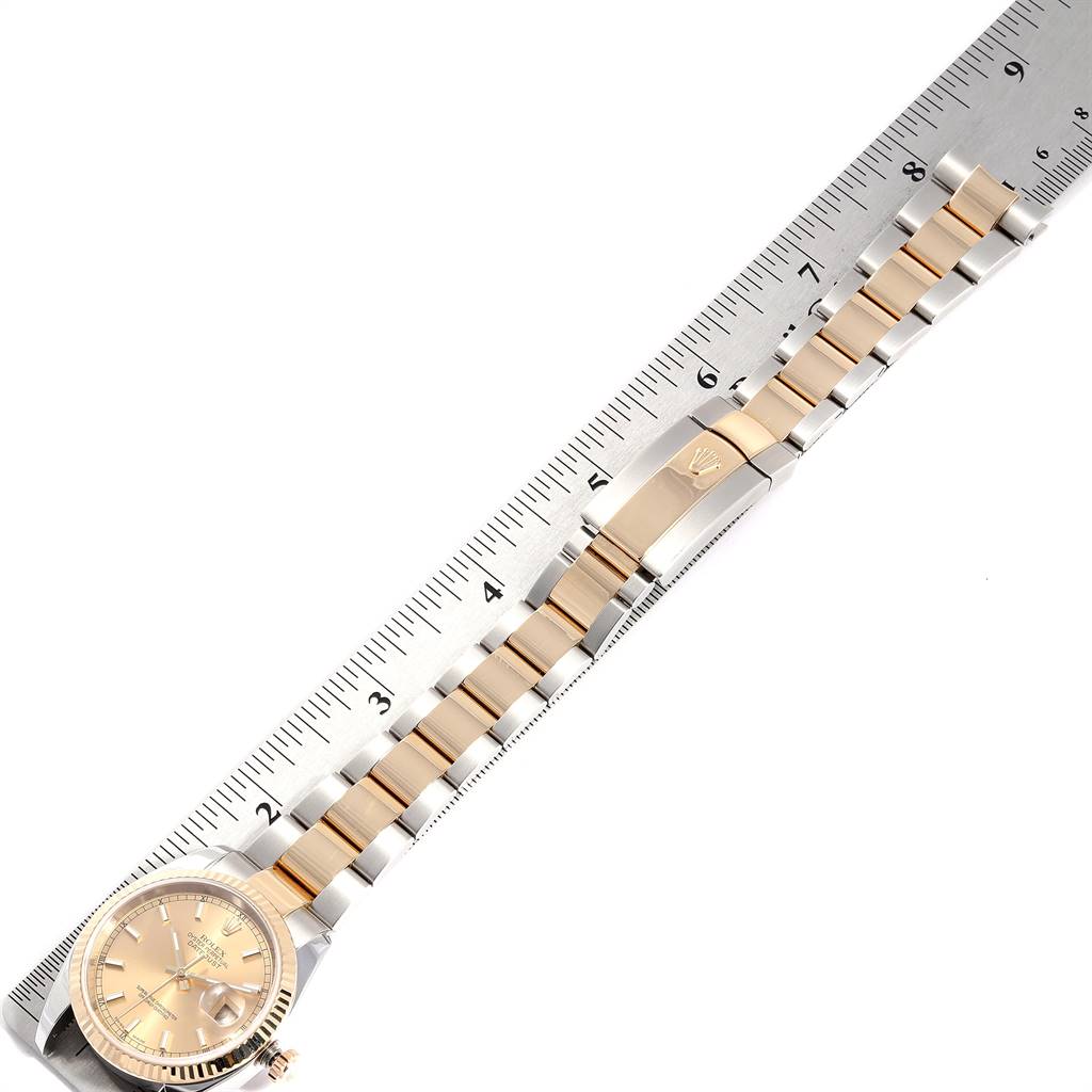 The image shows a top-down view of a Rolex Datejust 116233 Men's Stainless Steel Champagne Dial 116233 Men's Stainless Steel Champagne Dial watch with its band laid straight against a ruler.