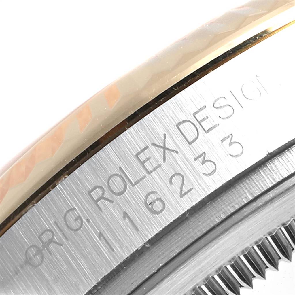 The image shows a close-up of the engraved bezel and fluted edge on a Rolex Datejust 116233 Men's Stainless Steel Champagne Dial 116233 Men's Stainless Steel Champagne Dial watch.