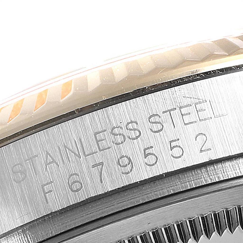 This image shows a close-up of the side bezel and part of the case back, with etched inscriptions, of a Rolex Datejust 116233 Men's Stainless Steel Champagne Dial 116233 Men's Stainless Steel Champagne Dial model.