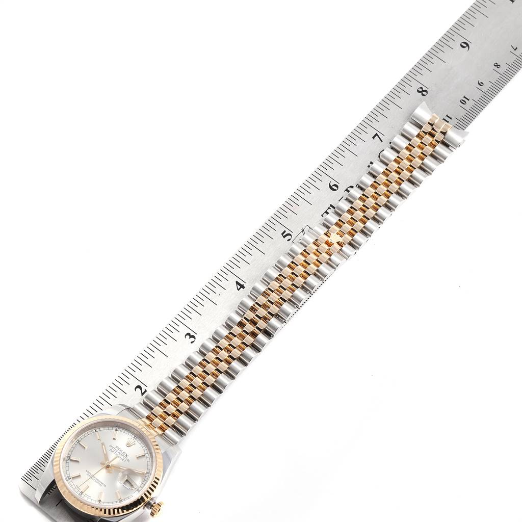 The Rolex Datejust 116233 Men's Stainless Steel Silver Dial 116233 Men's Stainless Steel Silver Dial watch is shown flat with its band and face fully extended next to a ruler for measurement.