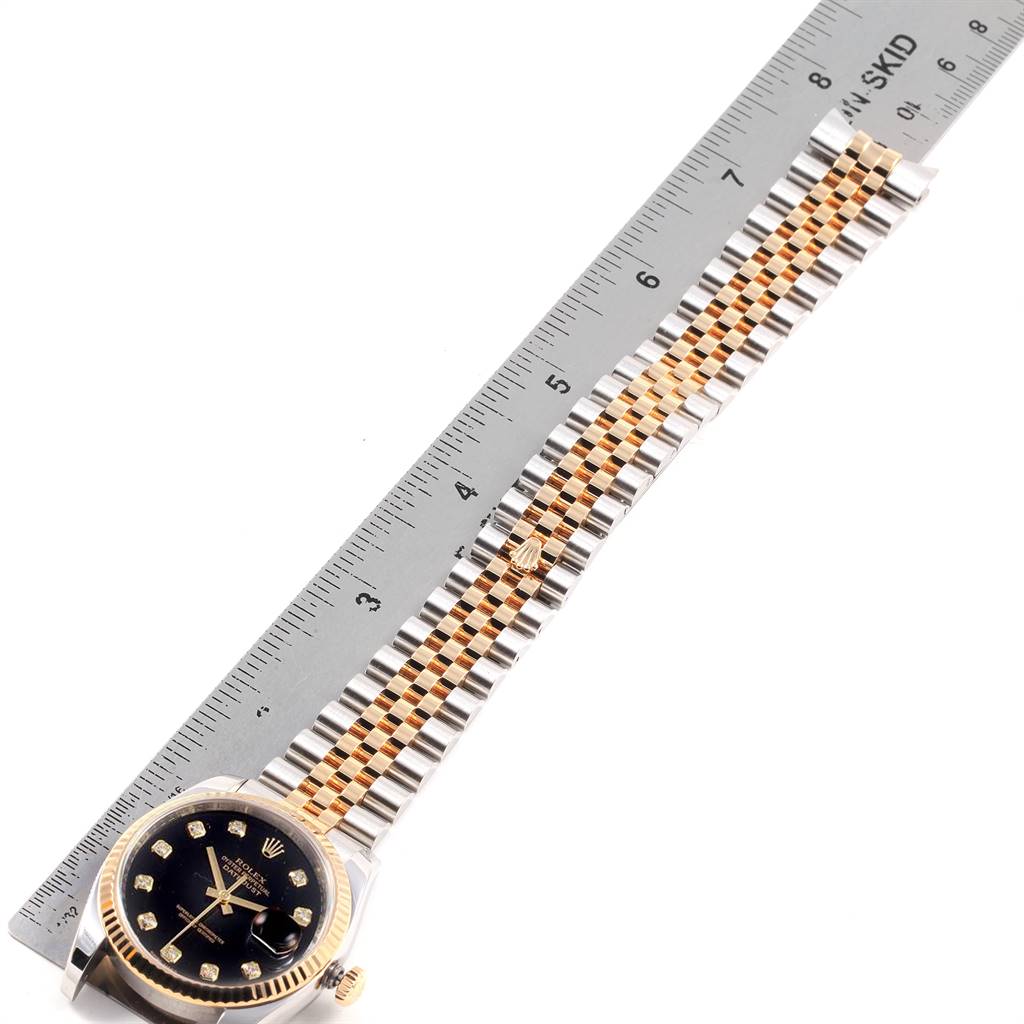 The image shows a Rolex Datejust 116233 Men's Stainless Steel Black Dial 116233 Men's Stainless Steel Black Dial watch layout flat, with a metal ruler next to it, highlighting its bracelet and face.