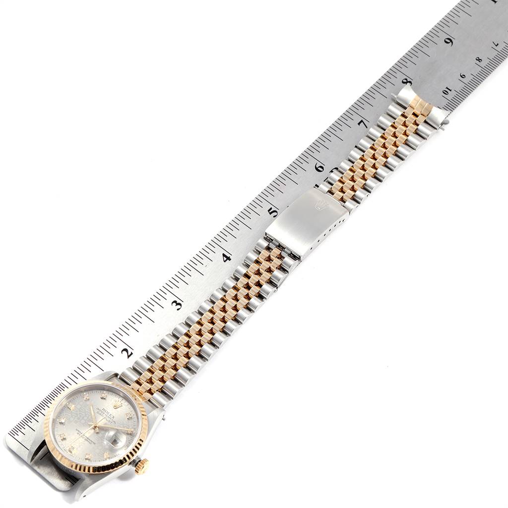The image shows a Rolex Datejust 16233 Men's Steel and Gold (two tone) Silver Dial 16233 Men's Steel and Gold (two tone) Silver Dial watch laid flat against a ruler, highlighting the face, bracelet, and clasp.