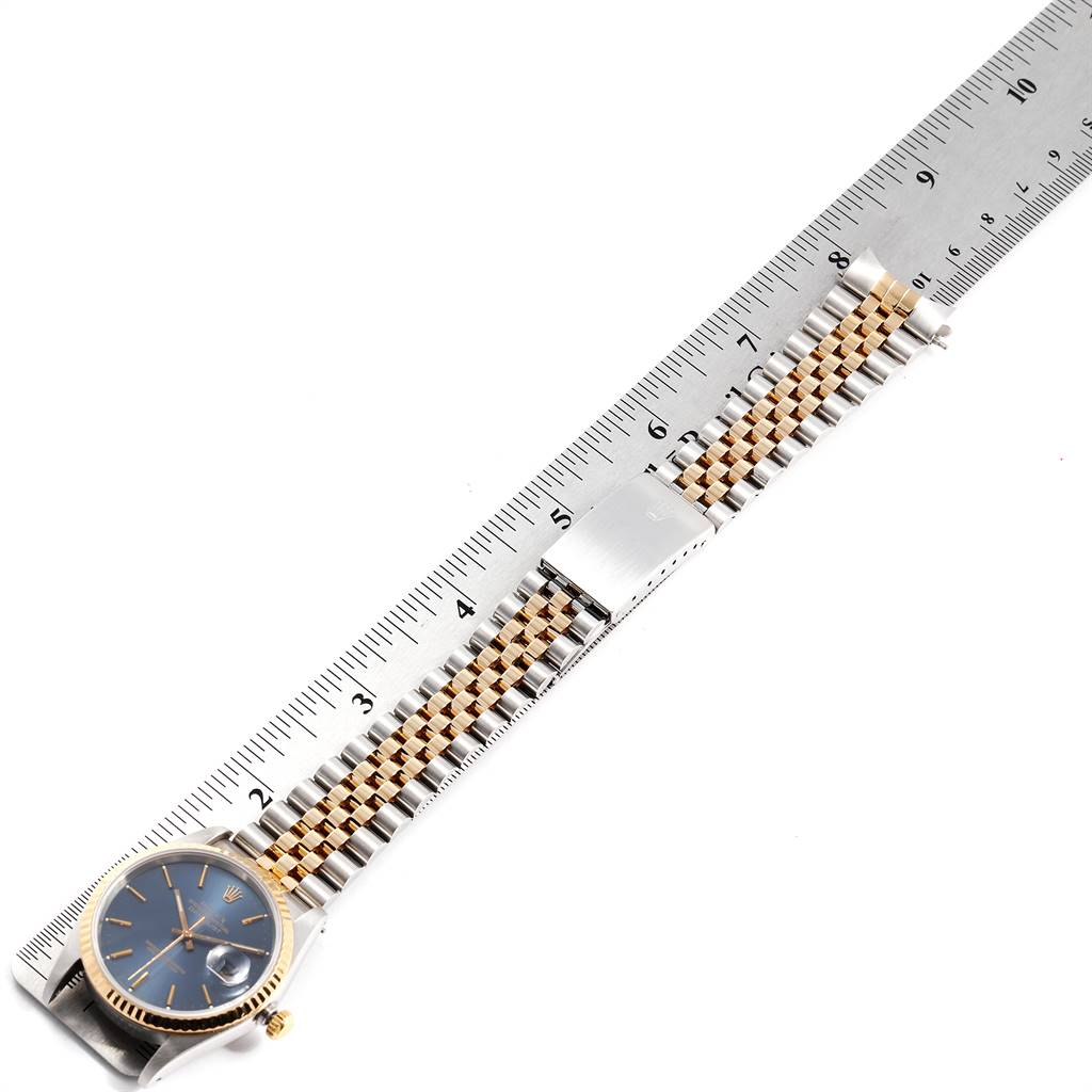 This image shows the Rolex Datejust 16233 Men
s Steel and Gold (two tone) Blue Dial 16233 Men
s Steel and Gold (two tone) Blue Dial watch laid flat next to a ruler, highlighting the face, bezel, and bracelet.