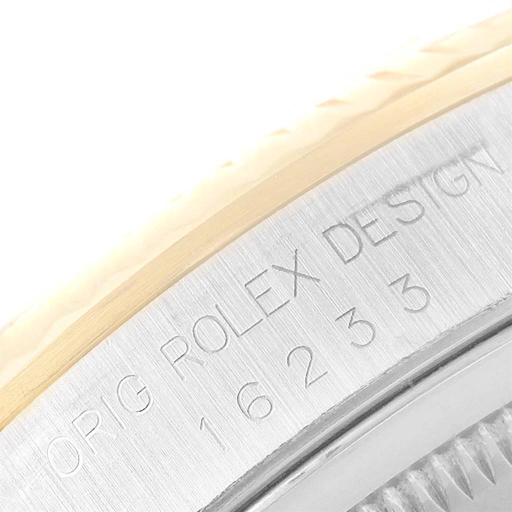 Close-up of the case side of a Rolex Datejust 16233 Men
s Steel and Gold (two tone) Blue Dial 16233 Men
s Steel and Gold (two tone) Blue Dial, showcasing the engraved text "ORIG ROLEX DESIGN 16233."
