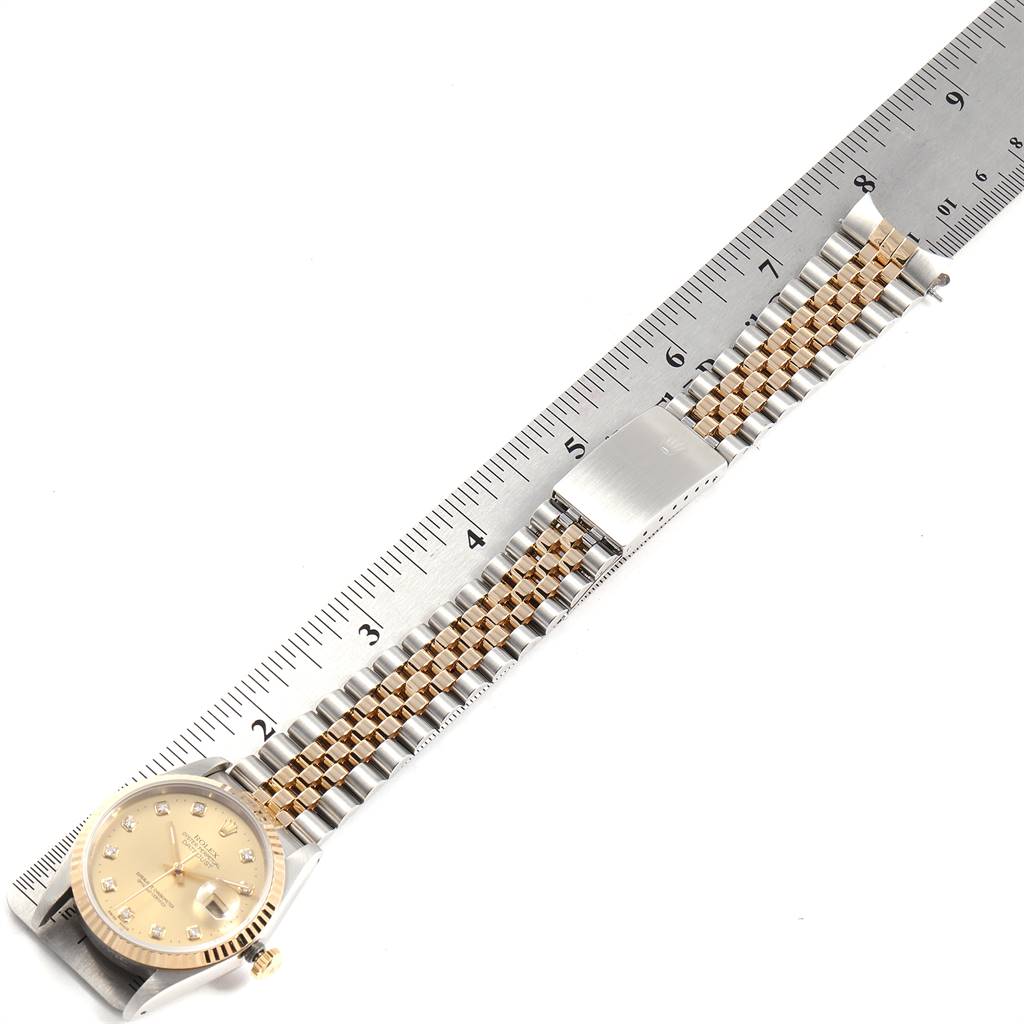 The image shows a Rolex Datejust 16233 Men's Steel and Gold (two tone) Champagne Dial 16233 Men's Steel and Gold (two tone) Champagne Dial watch from an overhead angle, displaying the watch face and the full length of the band next to a ruler.