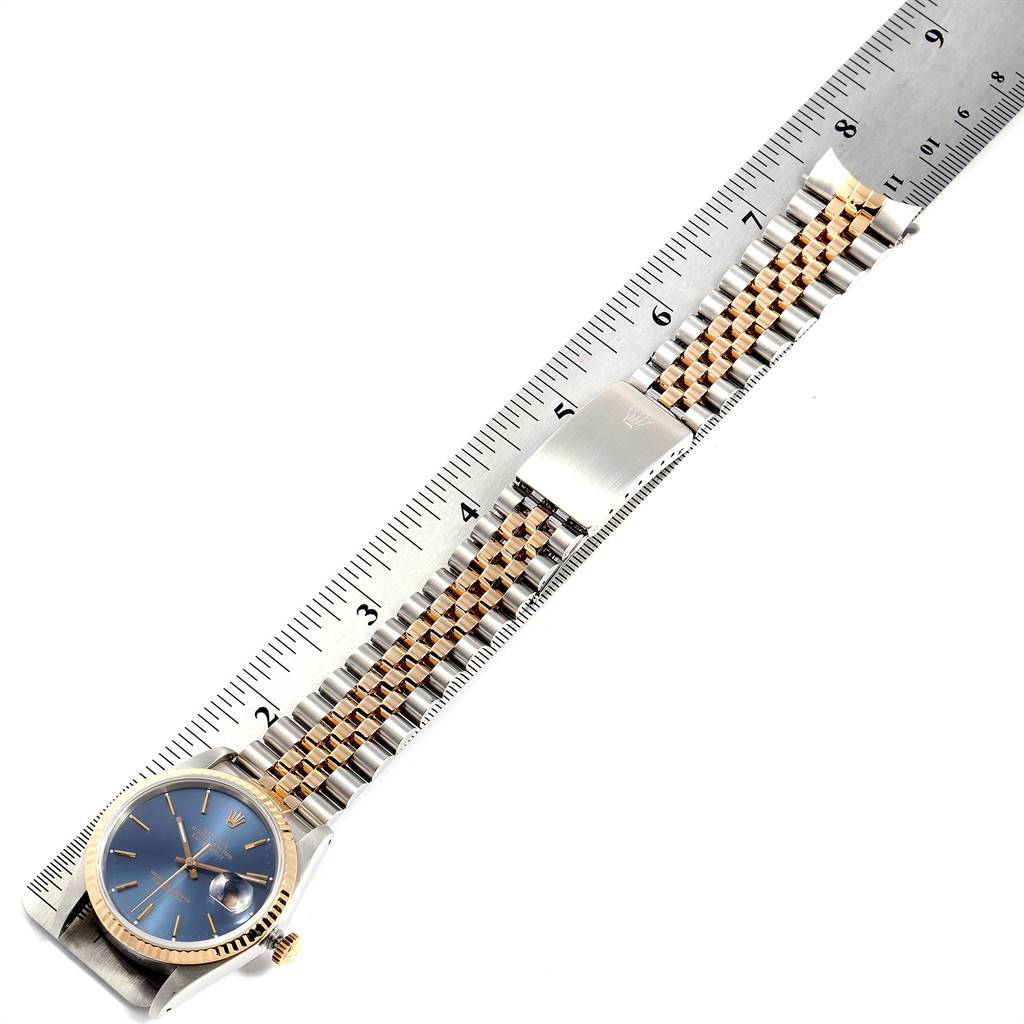 The image shows a Rolex Datejust 16233 Men's Steel and Gold (two tone) Blue Dial 16233 Men's Steel and Gold (two tone) Blue Dial model watch with its bracelet aligned with a ruler for measurement.