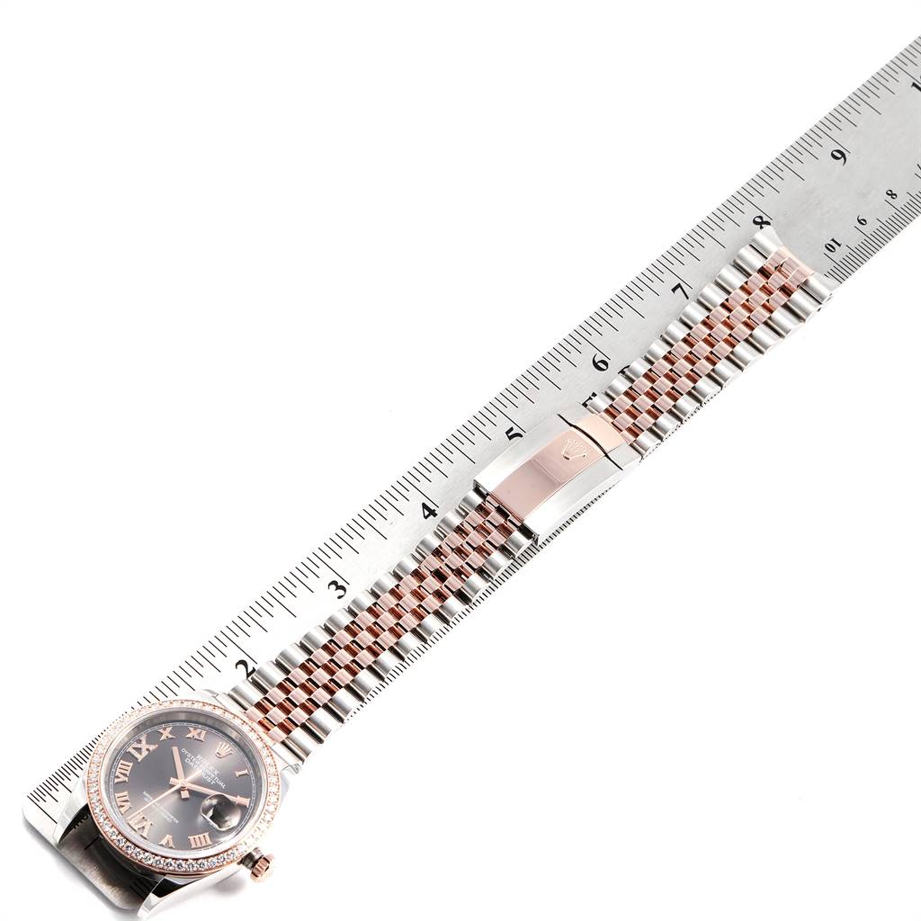 The Rolex Datejust 126281 Men's Steel and Gold (two tone) Grey Dial 126281 Men's Steel and Gold (two tone) Grey Dial watch is displayed from a top-down angle, showing the face, bracelet, and clasp alongside a ruler for scale.