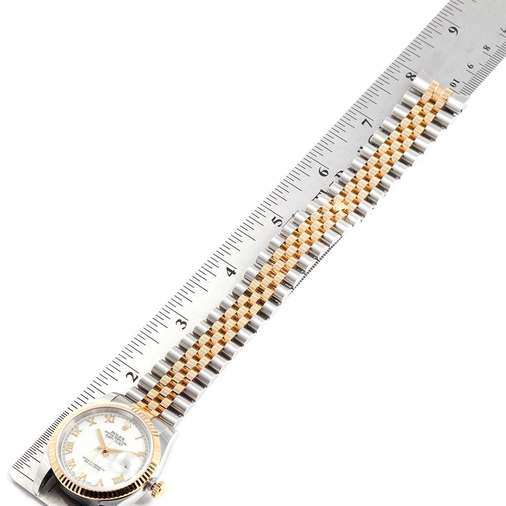 This image shows a Rolex Datejust 116233 Men's Stainless Steel White Dial 116233 Men's Stainless Steel White Dial watch placed on a ruler, displaying the face and the full length of the two-tone bracelet.