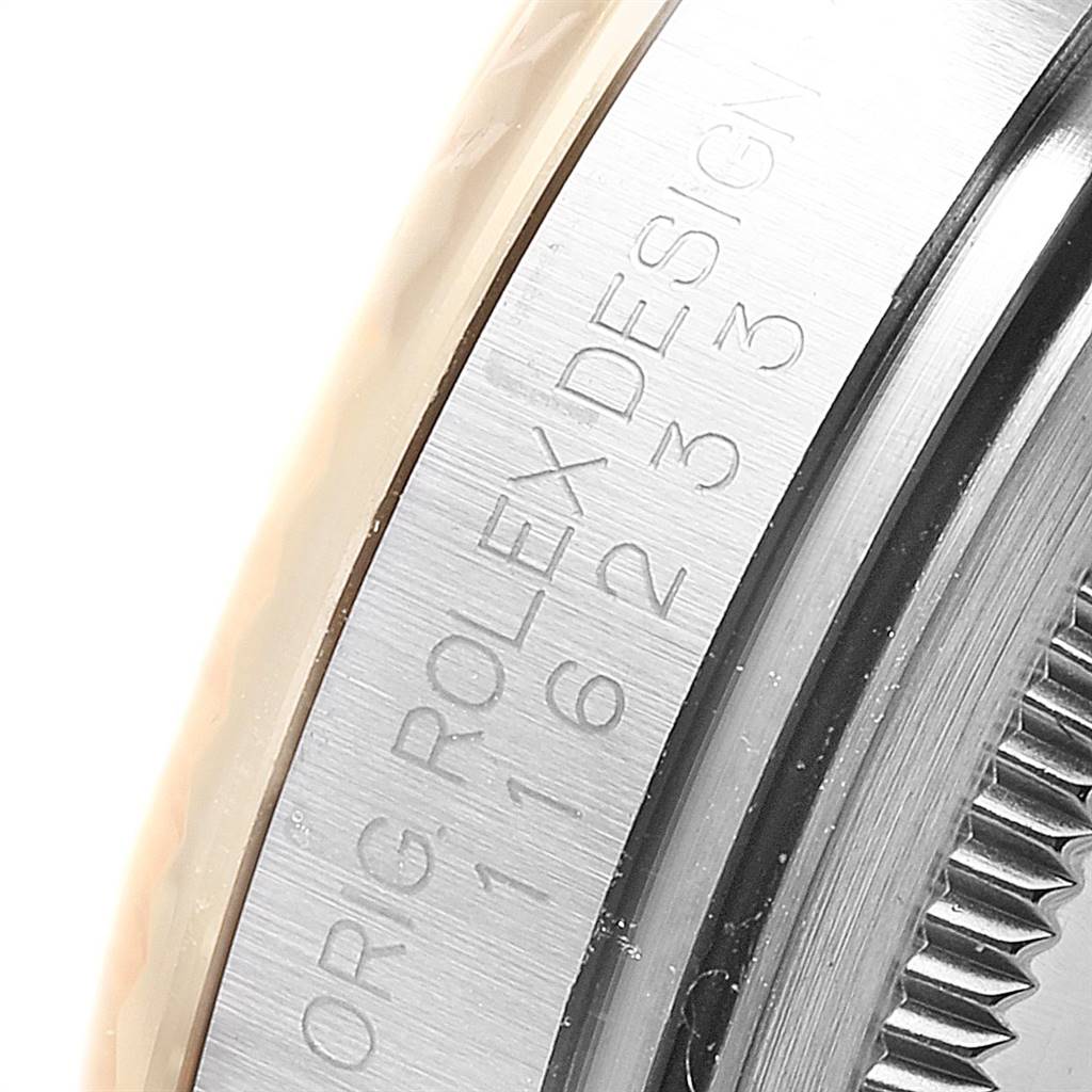 This close-up of the Rolex Datejust 116233 Men's Stainless Steel White Dial 116233 Men's Stainless Steel White Dial watch shows part of the bezel and the engraved text on the side of the case.