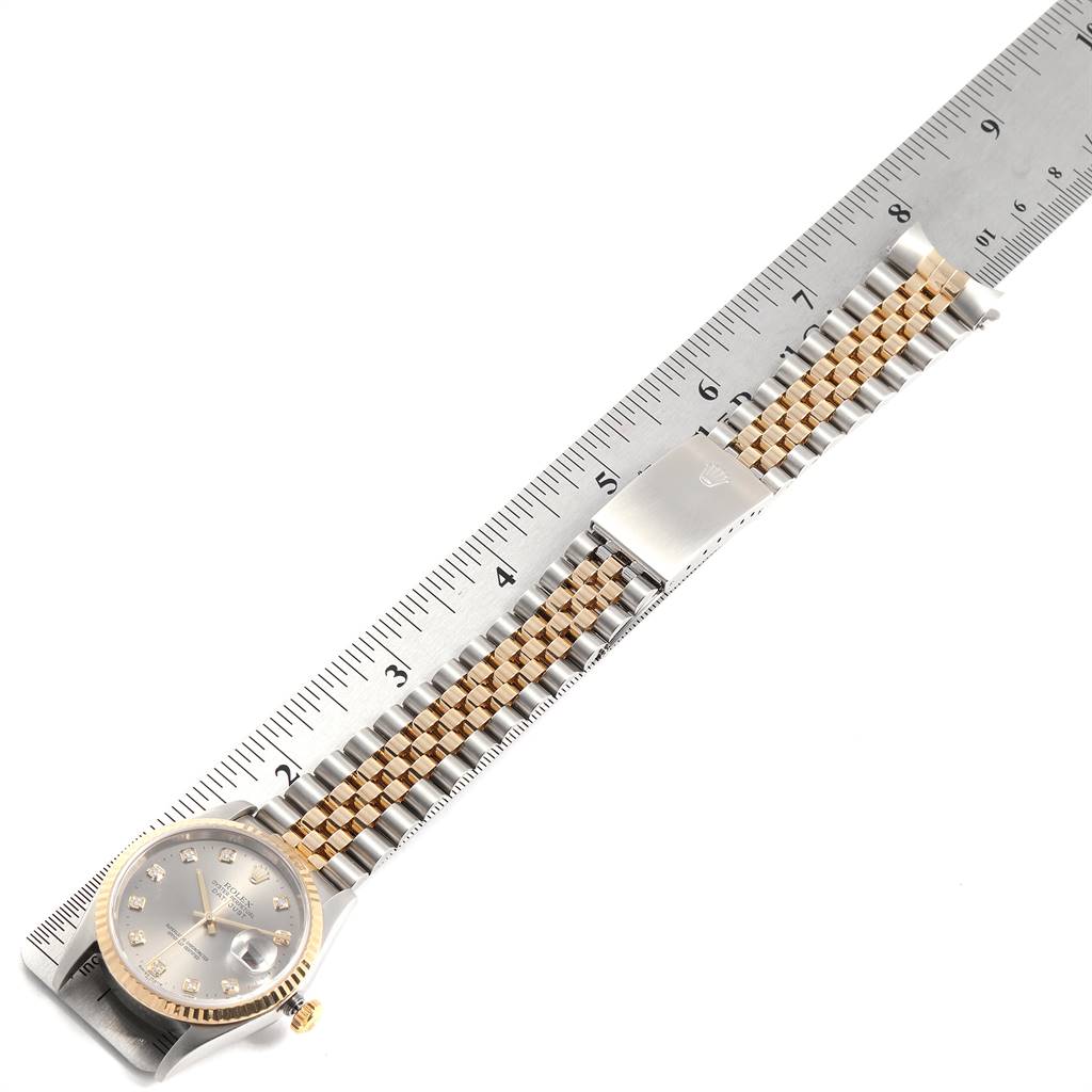 This top-down image shows the face and bracelet of a Rolex Datejust 16233 Men's Steel and Gold (two tone) Grey Dial 16233 Men's Steel and Gold (two tone) Grey Dial watch alongside a ruler for scale.