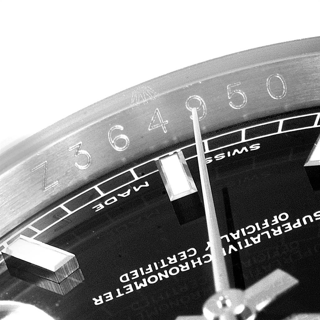This close-up of a Rolex Datejust 116200 Men's Stainless Steel Black Dial 116200 Men's Stainless Steel Black Dial watch shows the serial number on the bezel, part of the dial, and hour markers.