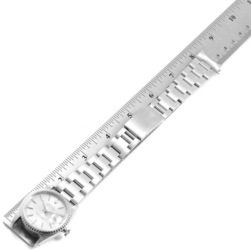 This image shows a top-view angle of a Rolex Datejust 16220 Men's Stainless Steel Silver Dial 16220 Men's Stainless Steel Silver Dial watch with its bezel, dial, and bracelet laid out against a ruler.