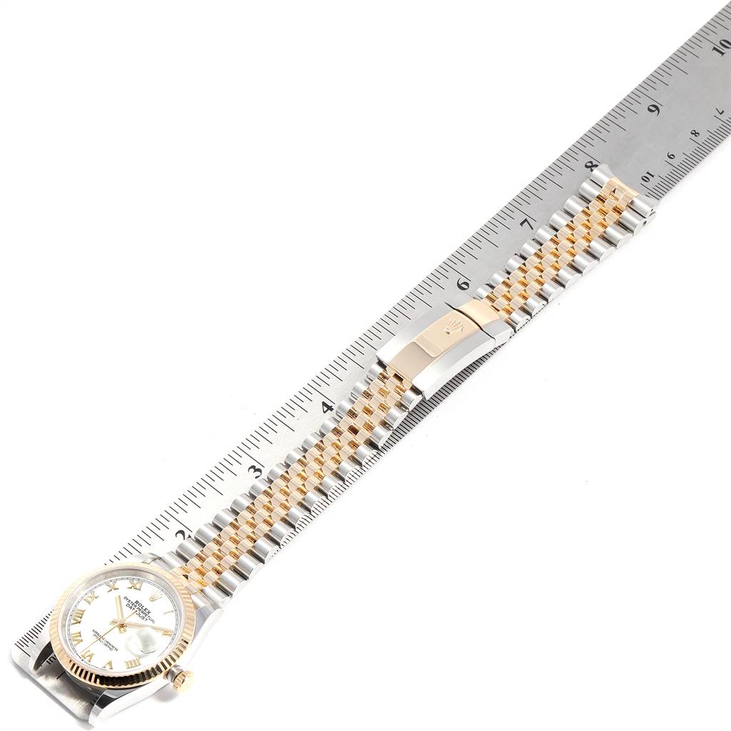 The Rolex Datejust 126233 Men
s Steel and Gold (two tone) White Dial 126233 Men
s Steel and Gold (two tone) White Dial watch is shown from the top, highlighting the face, bezel, and Jubilee bracelet against a ruler.