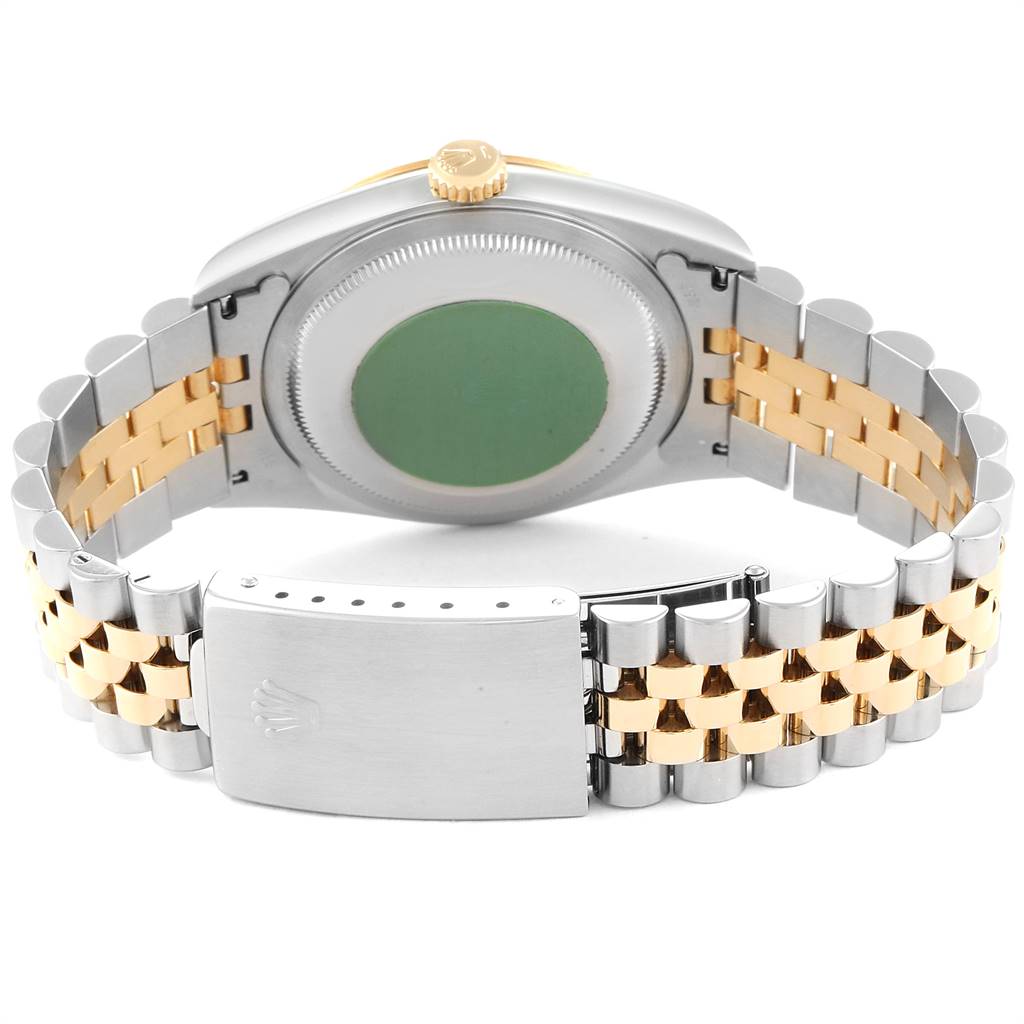 This image shows the back case with a green sticker, crown, and two-tone bracelet of a Rolex Datejust 16233 Men's Steel and Gold (two tone) Blue Dial 16233 Men's Steel and Gold (two tone) Blue Dial watch.