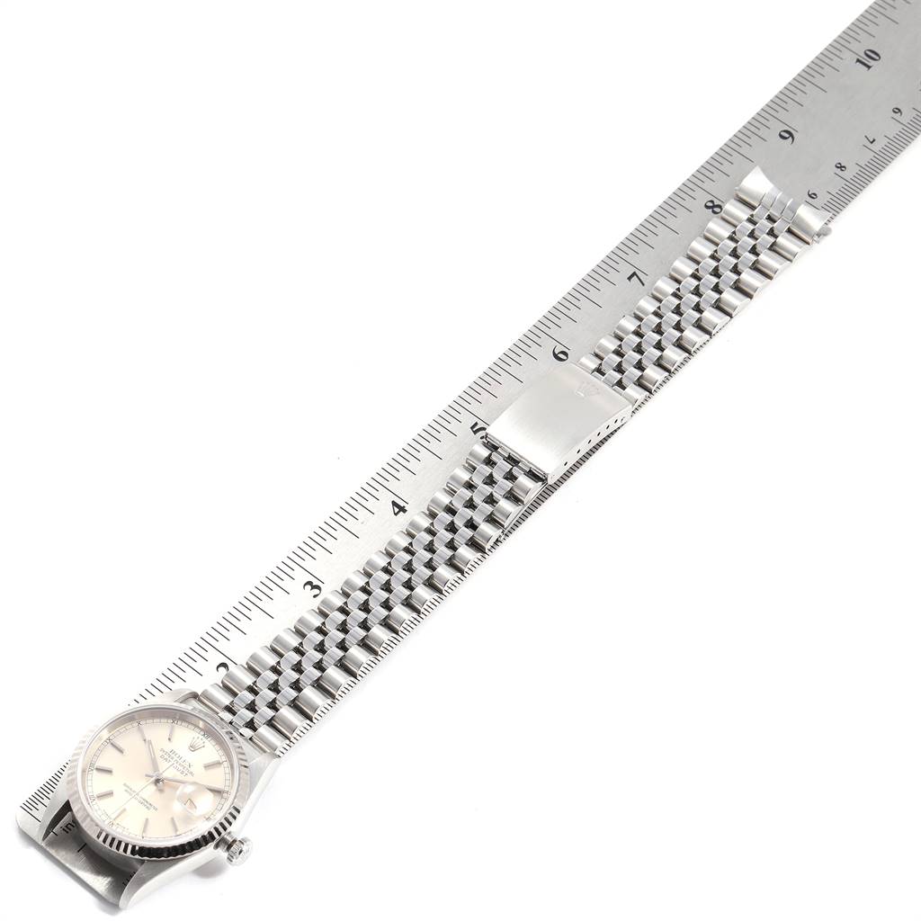 The image shows a Rolex Datejust 16234 Men's Stainless Steel Silver Dial 16234 Men's Stainless Steel Silver Dial watch from a top-down angle, highlighting the face, band, and clasp, with a measuring scale.