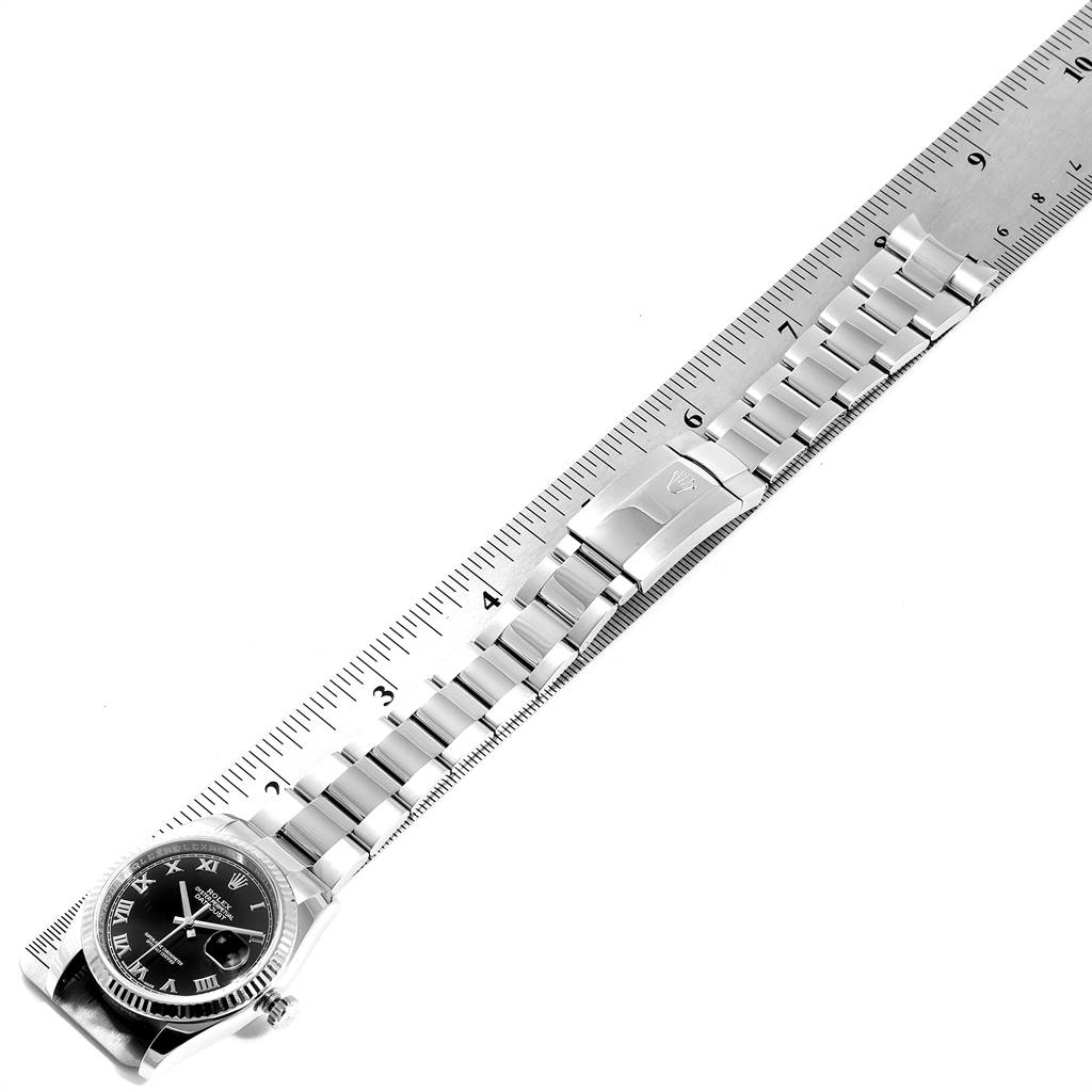 The image shows a top-down view of a Rolex Datejust 116234 Men's Stainless Steel Black Dial 116234 Men's Stainless Steel Black Dial watch on a ruler, featuring the dial, bezel, bracelet, and clasp.