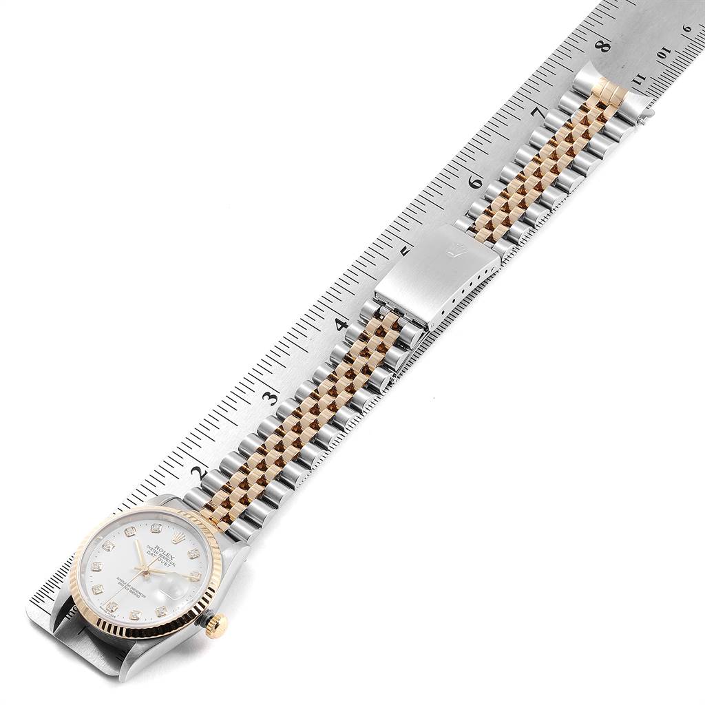 The image shows a Rolex Datejust 16233 Men's Steel and Gold (two tone) White Dial 16233 Men's Steel and Gold (two tone) White Dial watch laid flat against a ruler, displaying its dial, bracelet, and clasp.