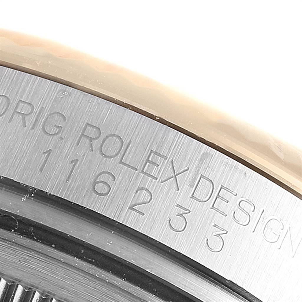 The image shows a close-up angle of the case side of a Rolex Datejust 116233 Men
s Steel and Gold (two tone) Blue Dial 116233 Men
s Steel and Gold (two tone) Blue Dial, highlighting the engraved serial numbers and "ROLEX DESIGN" text.