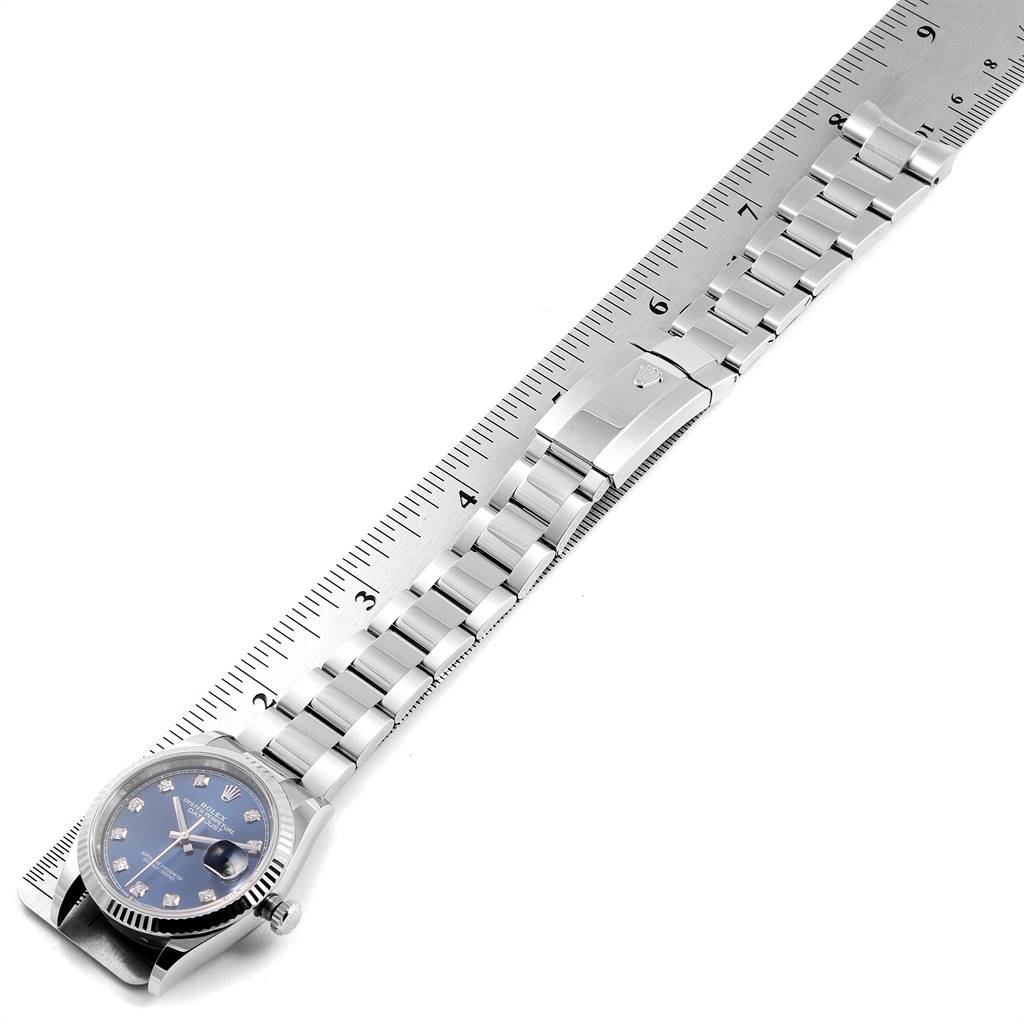 The image shows a Rolex Datejust 126234 Men's Stainless Steel Blue Dial 126234 Men's Stainless Steel Blue Dial watch laid flat from an overhead angle, with the bracelet extended and a ruler for scale.