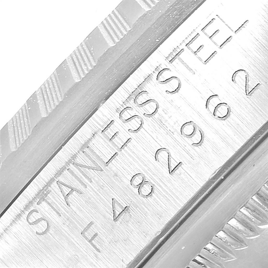 The image shows a close-up of the stainless steel bezel and serial number area of the Rolex Datejust 16220 Men's Stainless Steel Silver Dial 16220 Men's Stainless Steel Silver Dial model.