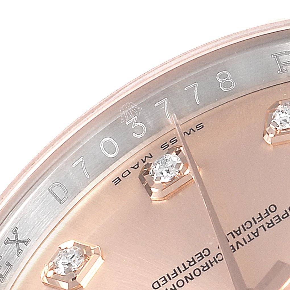 This close-up of a Rolex Datejust 116231 Men's Steel and Gold (two tone) Pink Dial 116231 Men's Steel and Gold (two tone) Pink Dial watch shows the dial, part of the bezel, diamond hour markers, and part of the serial number.