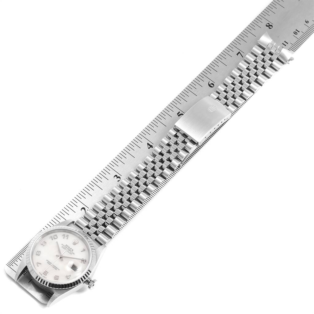 The image displays a Rolex Datejust 16234 Men's Stainless Steel Mother of Pearl Dial 16234 Men's Stainless Steel Mother of Pearl Dial watch laid flat along a ruler, showcasing the dial, bezel, and bracelet.