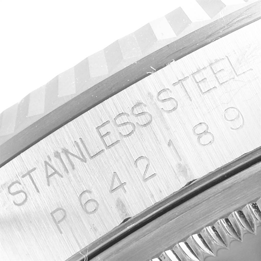 This close-up image of the Rolex Datejust 16234 Men's Stainless Steel Mother of Pearl Dial 16234 Men's Stainless Steel Mother of Pearl Dial shows part of the watch case with "STAINLESS STEEL" and a series of engraved numbers.