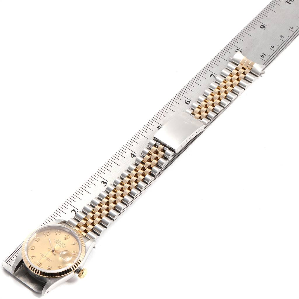 The image shows a Rolex Datejust 16233 Men's Steel and Gold (two tone) Champagne Dial 16233 Men's Steel and Gold (two tone) Champagne Dial watch lying flat next to a ruler, displaying the dial and the bracelet.