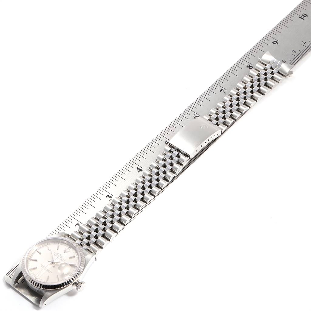 This image shows a Rolex Datejust 16234 Men's Stainless Steel Silver Dial 16234 Men's Stainless Steel Silver Dial watch placed next to a ruler, displaying its full bracelet and part of the watch face.