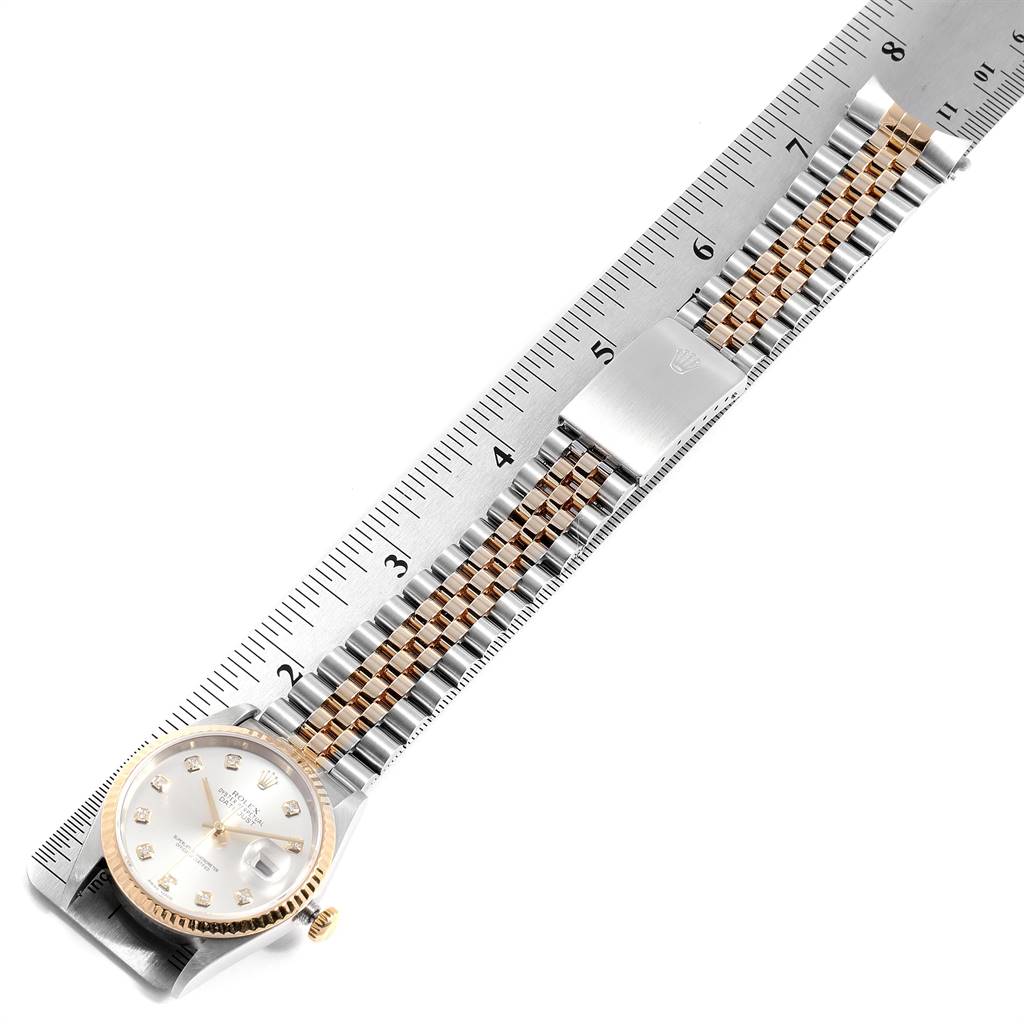The image shows a top-down view of the Rolex Datejust 16233 Men's Steel and Gold (two tone) Silver Dial 16233 Men's Steel and Gold (two tone) Silver Dial watch with a focus on the face and bracelet, placed alongside a ruler for scale.