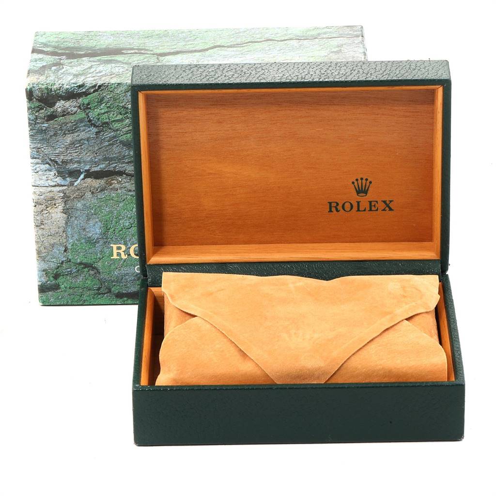 The image shows an open Rolex box containing a watch pouch, with the outer packaging also visible.