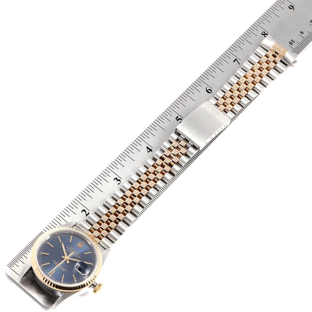 The image shows a Rolex Datejust 16233 Men's Steel and Gold (two tone) Blue Dial 16233 Men's Steel and Gold (two tone) Blue Dial watch with a ruler next to it, highlighting the bracelet and face.