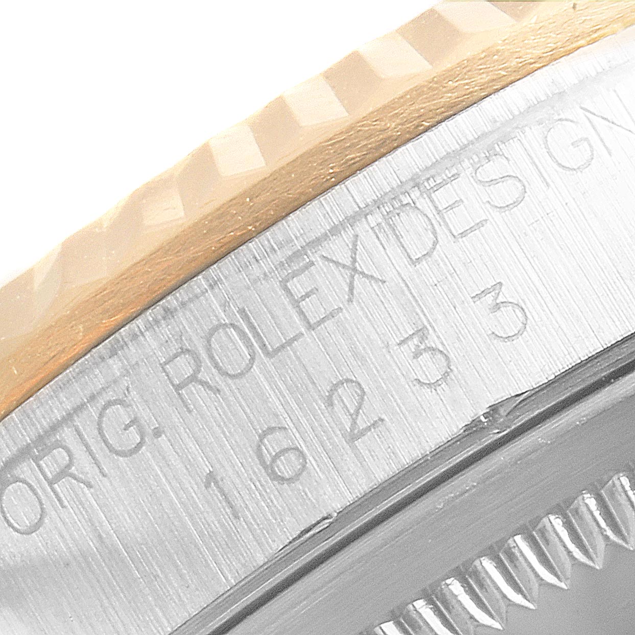 This close-up image shows the engraved side of the Rolex Datejust 16233 Men's Steel and Gold (two tone) Champagne Dial 16233 Men's Steel and Gold (two tone) Champagne Dial model, focusing on the bezel and case details.
