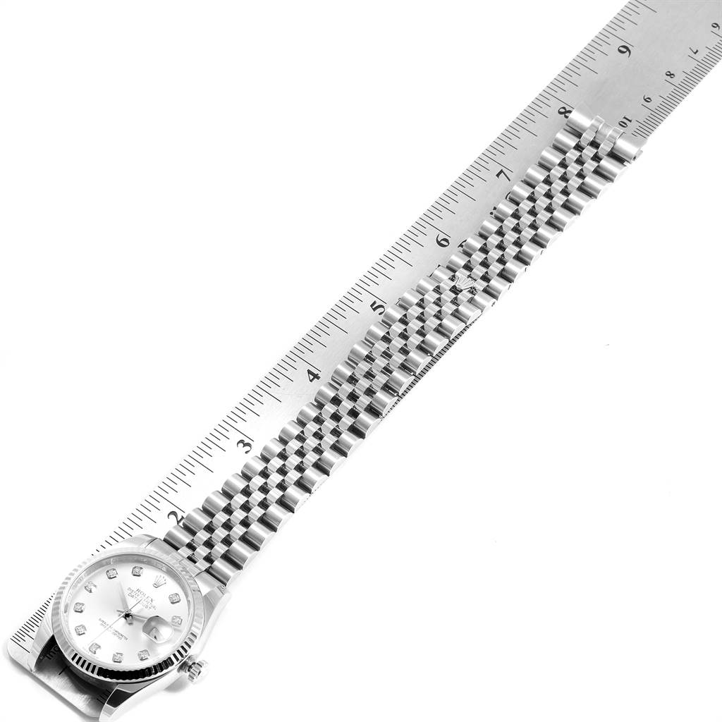 This image shows the Rolex Datejust 116234 Men's Stainless Steel Silver Dial 116234 Men's Stainless Steel Silver Dial watch laid flat alongside a ruler, displaying its face and bracelet.