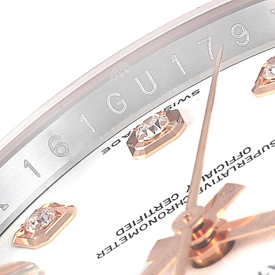 This close-up image of the Rolex Datejust 116231 Men
s Steel and Gold (two tone) White Dial 116231 Men
s Steel and Gold (two tone) White Dial watch shows part of the dial with diamond markers, hands, and the serial engraving.