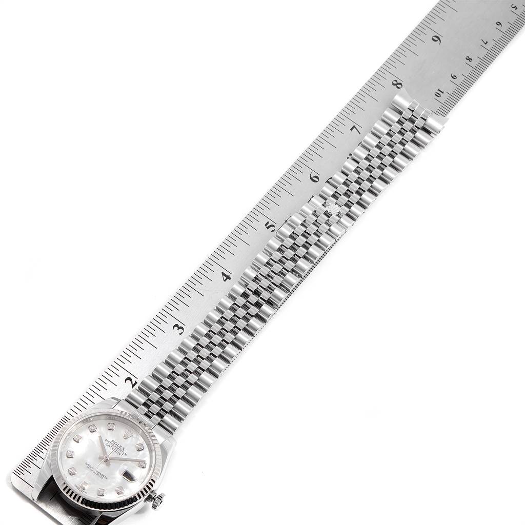 This image shows a Rolex Datejust 116234 Men's Stainless Steel Mother of Pearl Dial 116234 Men's Stainless Steel Mother of Pearl Dial watch positioned along a ruler, with both the dial and metal bracelet visible.
