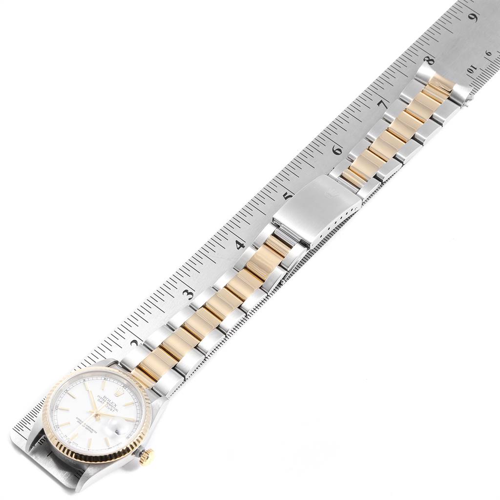 The image shows a Rolex Datejust 16233 Men's Steel and Gold (two tone) White Dial 16233 Men's Steel and Gold (two tone) White Dial watch from an overhead angle with its bracelet laid over a ruler.